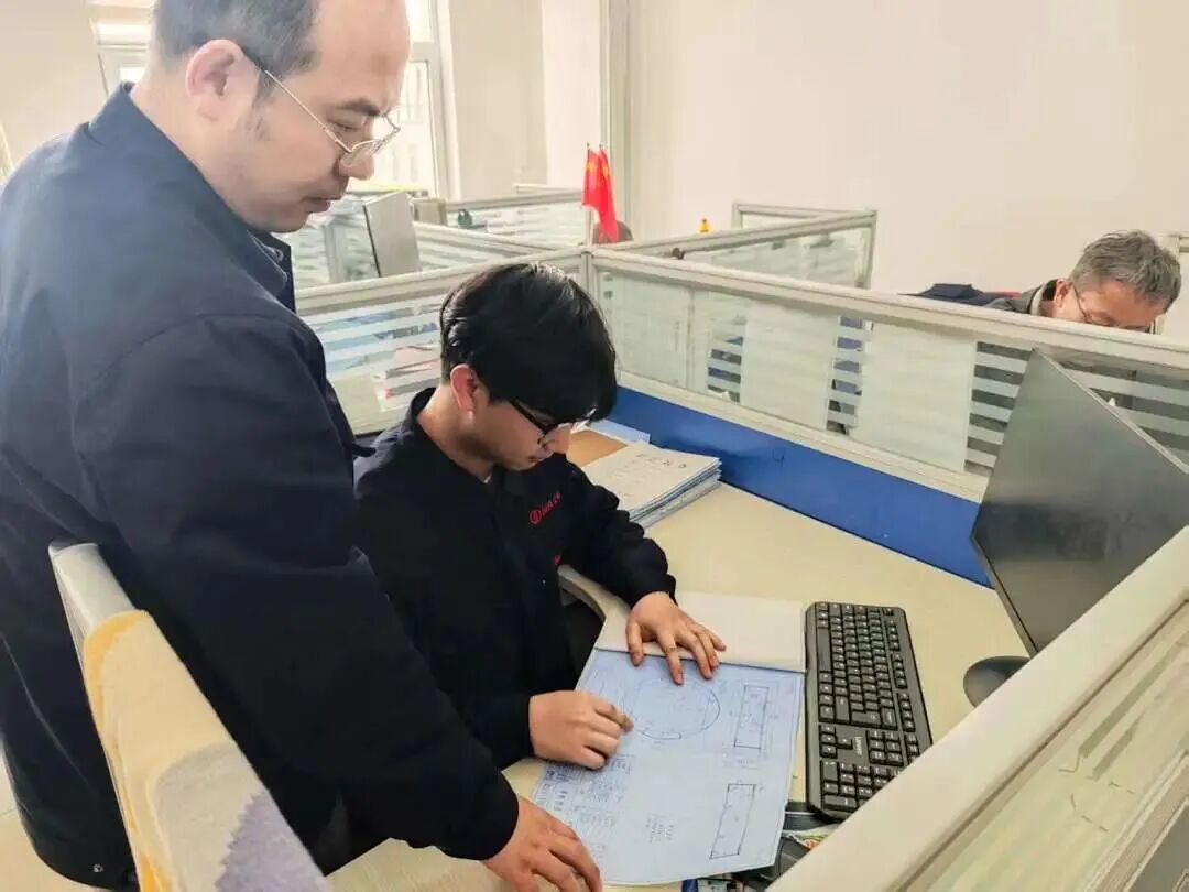 ▲公司业务骨干与“带编入企”引进人才研讨设计图纸。